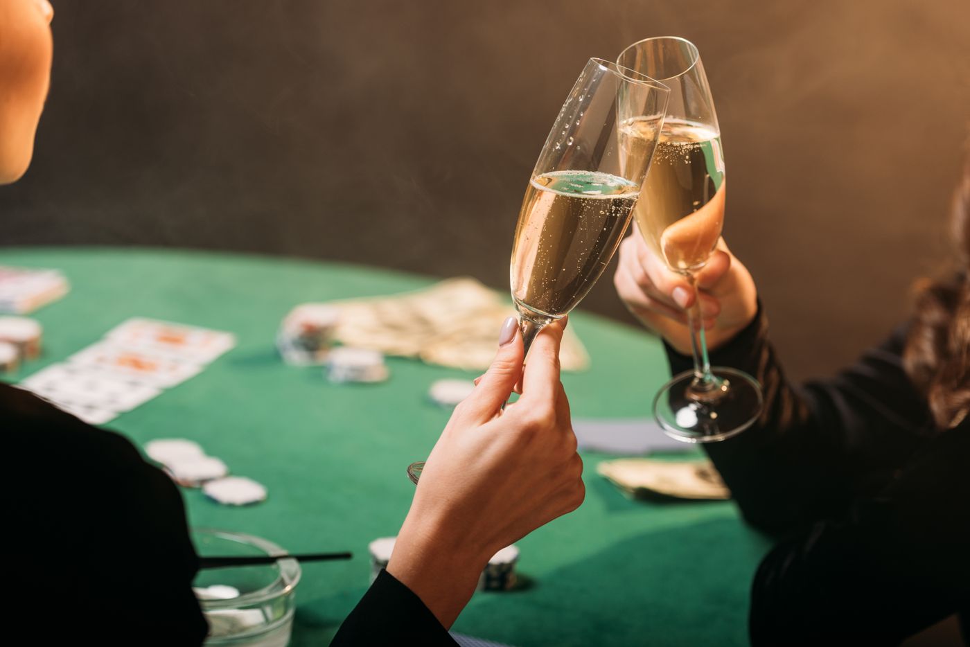 Brinde com flutes de espumante sobre mesa de casino